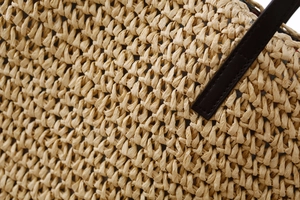 Gros plan détaillé de la texture en paille tressée avec coutures en cuir marron