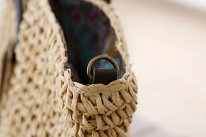 Détails de la paille de papier tissée avec anneaux en bronze et bandoulière en cuir vintage