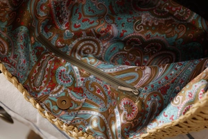 Détail du sac en paille avec doublure cachemire, fermeture éclair et fermoir aimanté