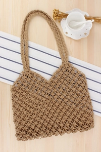 Detailed close-up of handmade hollow paper rope woven tote bag on a rustic table