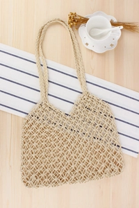 Flat lay of handmade hollow woven paper string bag with reinforced handles in beige