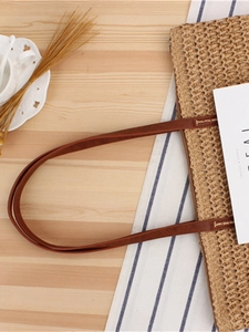 Beige woven straw tote bag with brown leather handles for summer beach or daily use