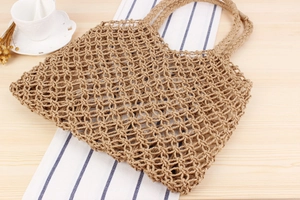 Macro detail of natural straw hollow mesh tote bag with artisanal woven texture