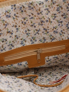 Straw woven shoulder bag interior showing floral lining and secure zipper pocket