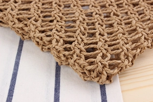 Macro shot of natural brown paper rope woven mesh texture on a hollow handbag