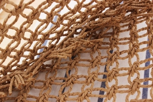 Macro shot of hand-woven paper rope bag showing intricate knot details and texture