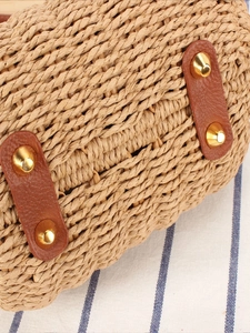 Vue du fond d'un sac en paille tressée avec renforts en cuir et clous de protection dorés