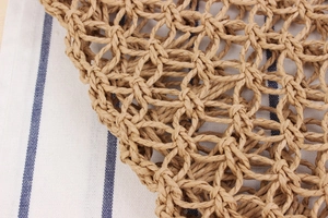 Detail shot of hollow hand-woven paper rope bag with intricate natural mesh texture