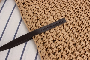 Detail of handwoven paper straw bag with premium leather strap and neat stitching