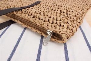 Detail of hand-woven paper rope bag with secure zipper closure and leather handles