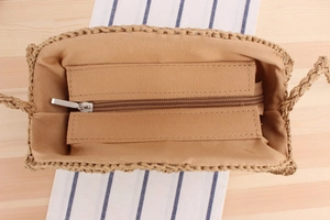 Internal view of round woven bag showing smooth brown zipper and soft fabric lining