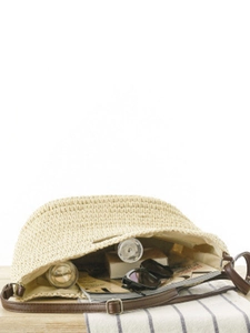 Straw woven crossbody bag with brown leather strap and large interior storage space