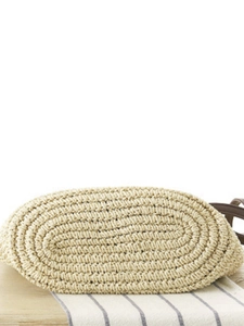 Oval base of a summer paper rope woven bag with a spiral pattern and leather strap details