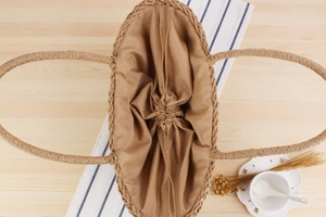 Close-up of woven hollow handbag with drawstring inner pouch on a rustic table