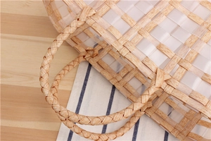 Detailed close-up of handmade woven basket bag with wood-grain texture and clear plastic