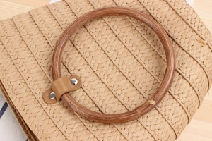 Dettaglio del manico in legno e della trama in paglia di questa borsa a secchiello