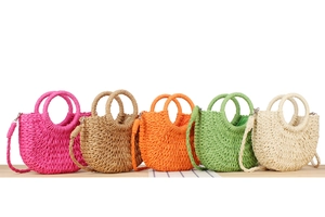 Detailed view of woven straw handbags in five vibrant colors for summer vacation