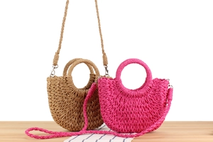Detail of woven crescent beach bags in brown and rose pink with detachable straps