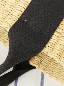 Minimalist woven straw tote bag with black canvas handles and high-quality stitching