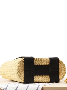 Chic straw woven handbag with black canvas straps and a minimalist summer vacation aesthetic