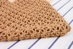 Close-up of the detailed handmade woven texture on the light brown shoulder bag