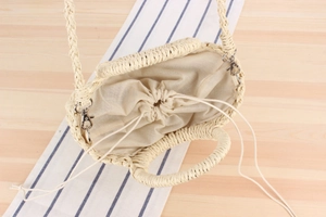 Detail of cream woven straw bag with drawstring lining and detachable shoulder strap