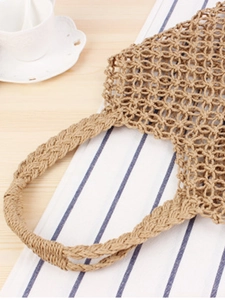 Handmade hollow woven paper rope tote bag with rustic braided handles for a vacation style