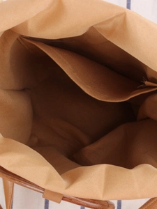 Vista interna della borsa a secchiello in paglia intrecciata con fodera cachi e tasca