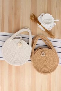 Detailed view of round woven cotton rope bags in beige and tan with dandelion wood buttons