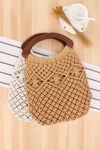 Detail of handmade cotton rope woven beach bag with dark semi-circular wooden handles