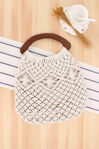 Detailed close-up of handmade off-white cotton rope weave with vintage brown wooden handle