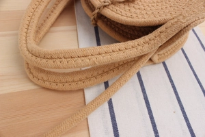 Close-up of circular woven cotton rope pattern and handle detail on a beach tote bag