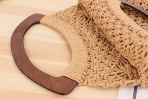Close-up of handmade woven cotton rope beach bag with semi-circular wooden handles