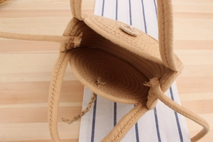 Macro shot of circular woven bag showing natural texture, spiral weave and wooden button
