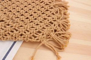 Close-up of woven cotton rope bag showing intricate hollow star patterns and tassels