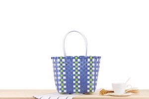 Close-up of blue and green checkered woven basket bag with clear round handles