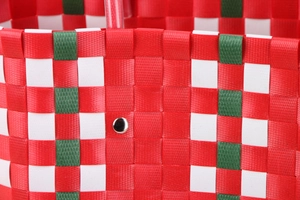 Close-up of woven checkered beach bag with red, white and green pattern and metal rivet