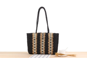 Detailed texture of vertical striped paper rope woven shoulder bag for summer beach