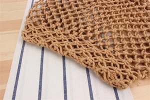Gros plan sur un sac en filet marron tissé à la main avec détails de nœuds en coton