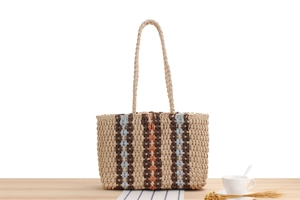 Detailed view of striped straw tote bag showing tight weave texture and vertical patterns