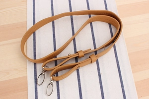 Detail of adjustable camel faux leather strap with silver metal hooks for paper rope bags