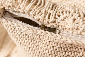 Detailaufnahme der gewebten Baumwolltextur und des Vintage-Metallreißverschlusses der Tasche