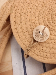 Circular woven cotton rope crossbody bag with decorative wooden tree button closure
