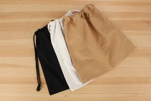 Detailed view of canvas drawstring inner pouches in black, white and natural flax colors