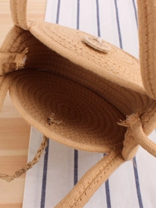 Handcrafted circular woven cotton rope crossbody bag with natural wooden buckle closure