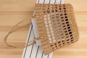 Detailed view of large capacity hollow woven paper rope tote bag on wooden surface