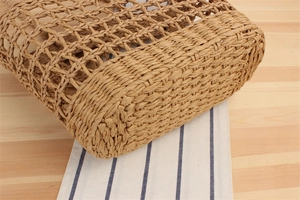 Close-up of handmade woven paper rope bag with hollow diamond mesh pattern and flat base