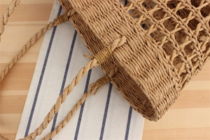 Close-up of hand-woven hollow paper rope bag with detailed mesh texture and natural fiber handles