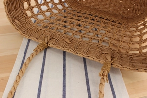 Detail of handmade woven paper rope tote bag showing handle attachment and mesh texture
