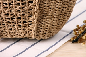Detailed close-up of natural woven paper straw texture on a summer beach handbag